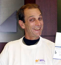 Man in a white tshirt smiles for the camera