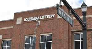 External shot of a two-story brick Louisiana Lottery building on a city street.