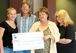Man, woman, and two girls pose with giant check in a Louisiana Lottery office
