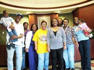 Group of men, women, and children smile for the camera in a Louisiana Lottery office lobby
