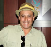 Man in a light green button down and a brimmed hat smiles in a Louisiana Lottery office