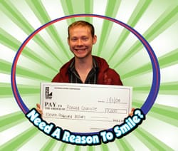 Man smiles with oversized check in a cartoon circle that reads "Need a Reason to Smile?" over a green striped digital background