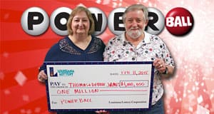 Man and woman hold oversized check and smile in front of red Powerball branded background